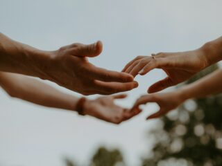 a group of people reaching out their hands