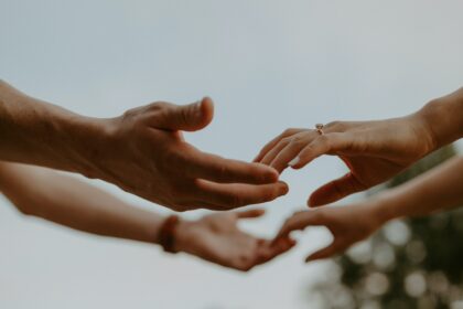 a group of people reaching out their hands